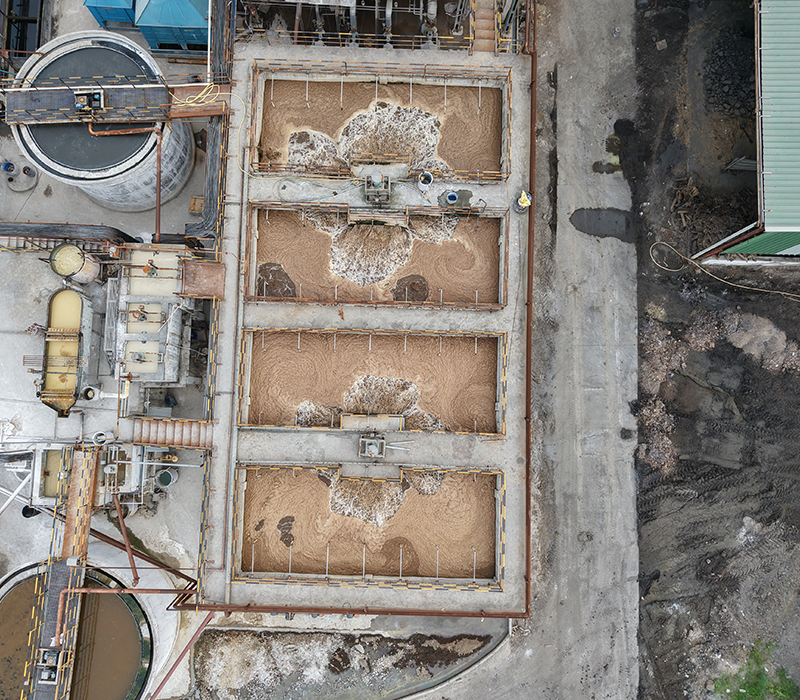 erial view of a large-scale industrial wastewater treatment facility with aeration basins and clarifiers by Distingon Engineers & Consultant Pvt. Ltd.